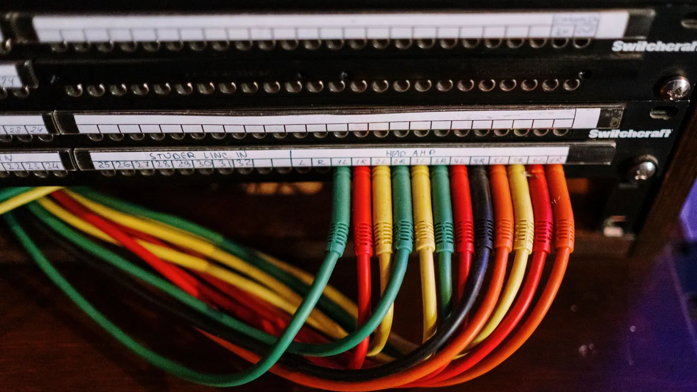 Close-up of colourful labelled patch cables plugged into a network panel
