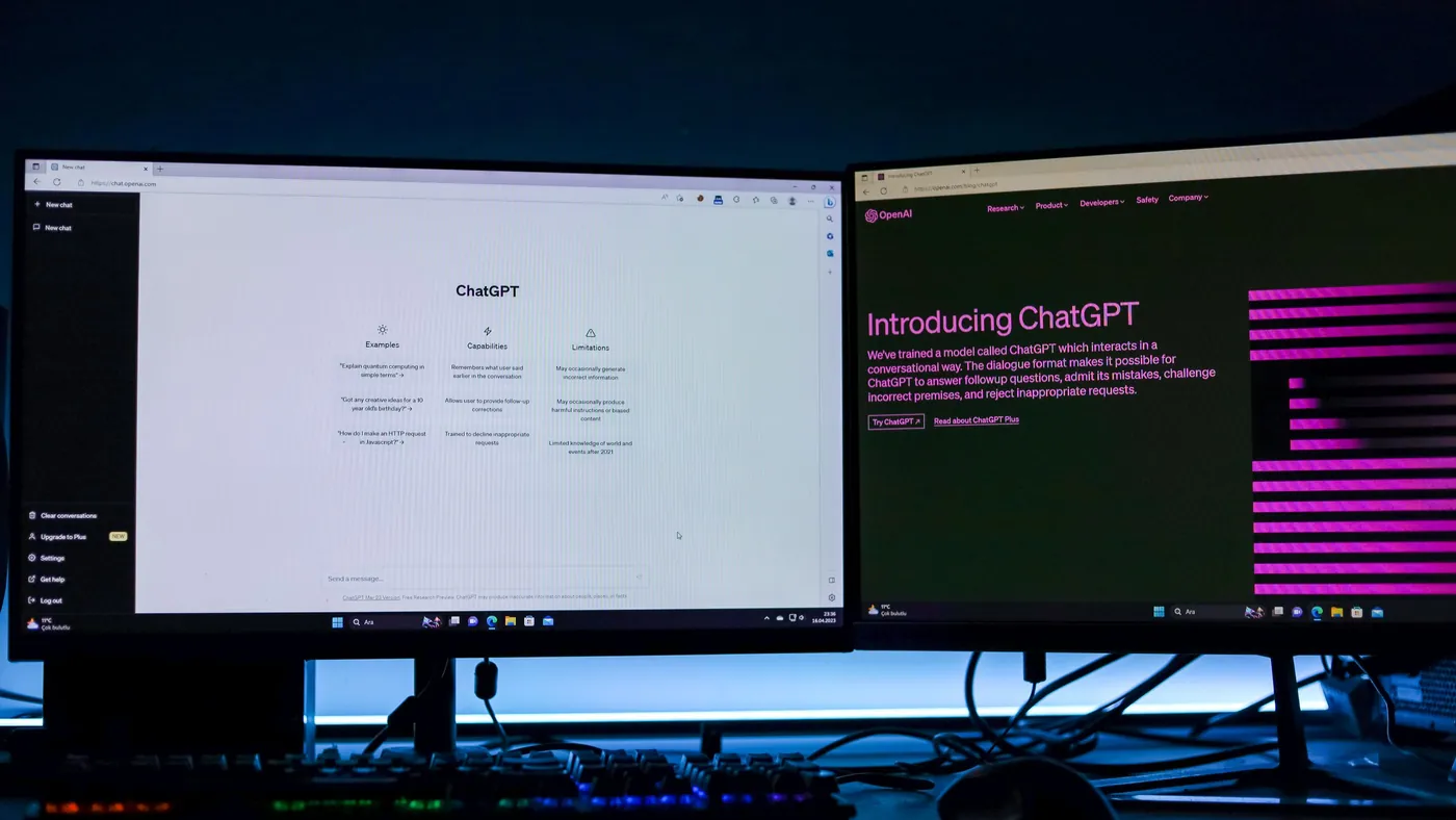 Two monitors side by side on a desk, each displaying a chat interface